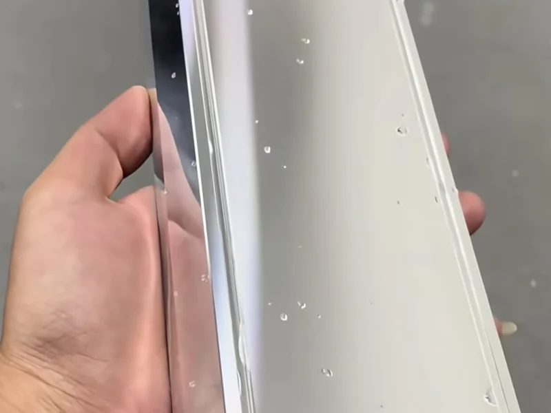 Profilé métallique réfléchissant tenu pour une inspection visuelle.