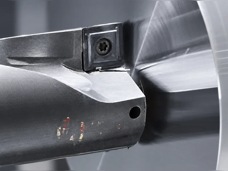 An internal machining tool positioned at a metal bore.