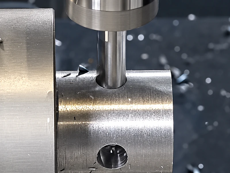 Close-up of a tool machining a cylindrical metal component.