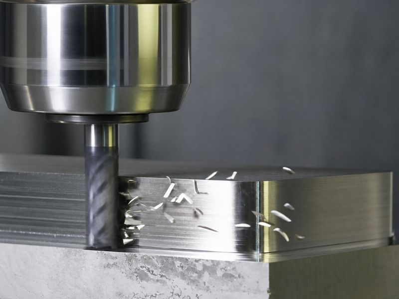End mill using its peripheral cutting edges to machine one side wall of a metal workpiece.