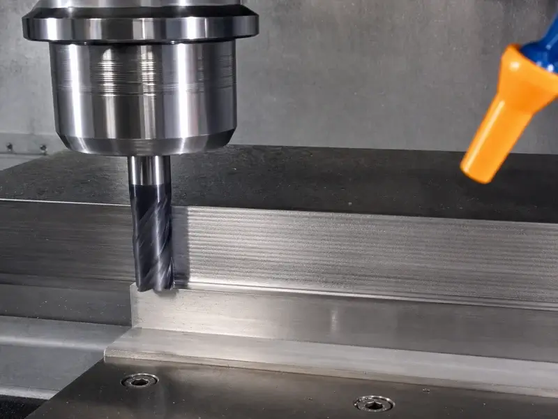End mill machining a metal wall with visible periodic milling chatter marks.