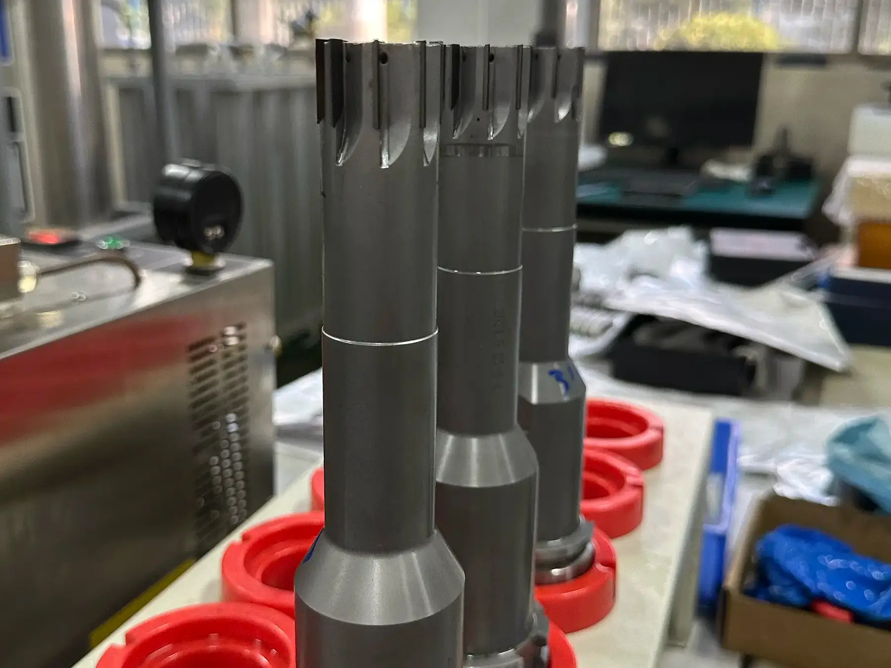 PCD reamers mounted in red tool holders in an industrial workshop.