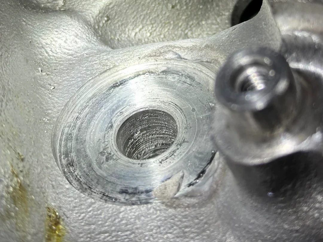 Close view of a weld-repaired aluminum bore with visibly torn and marked surface finish.