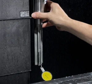 A reamer assembly held in a machine spindle while a dial indicator checks runout.
