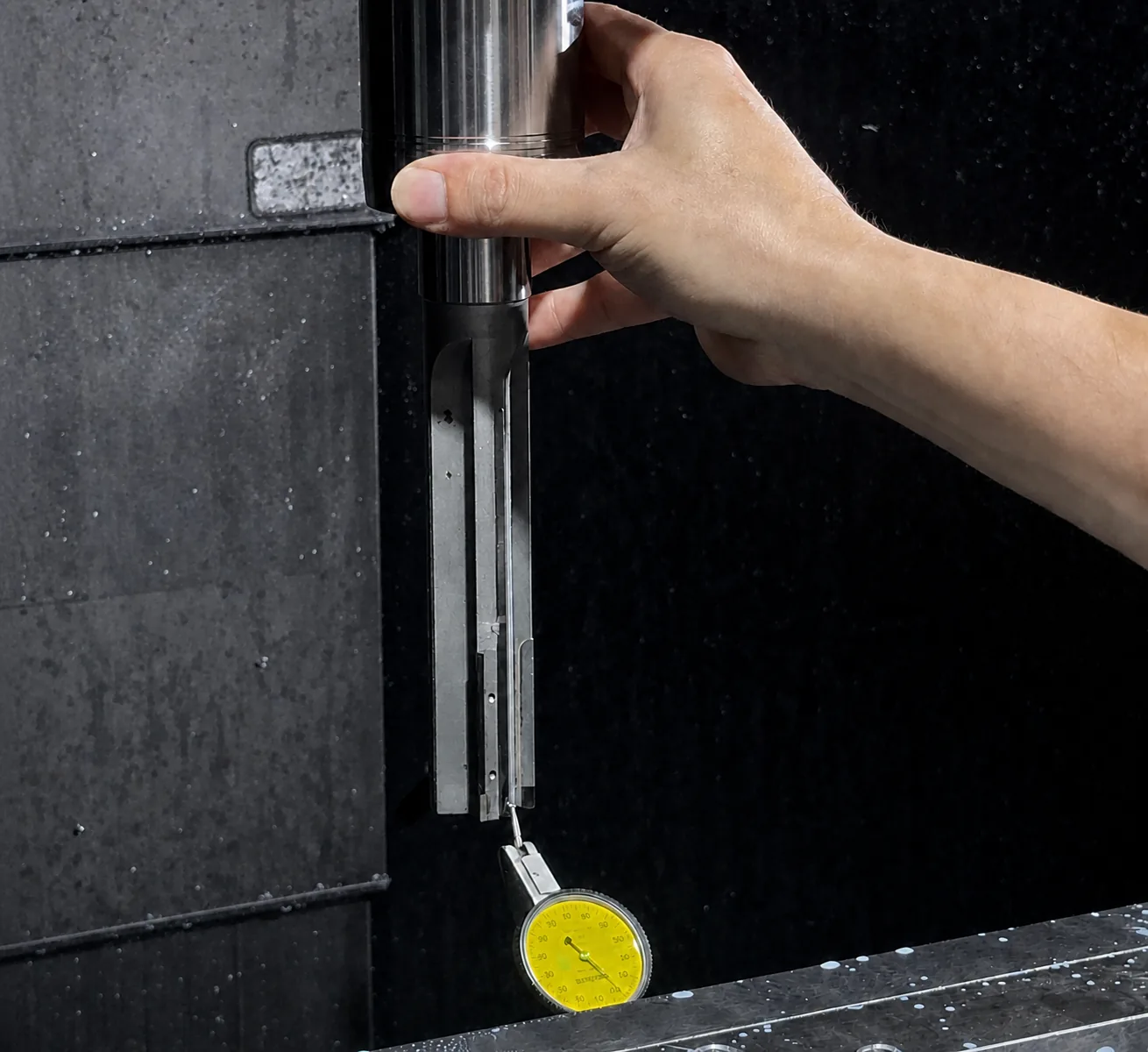 A reamer assembly held in a machine spindle while a dial indicator checks runout.
