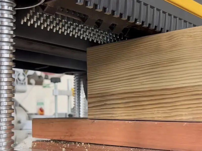 Wood beside a planer cutterhead with multiple cutting elements