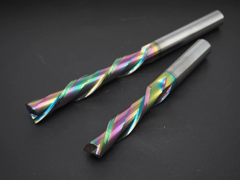 Two spiral cutting tools photographed on a gray background, showing their flutes and shanks.