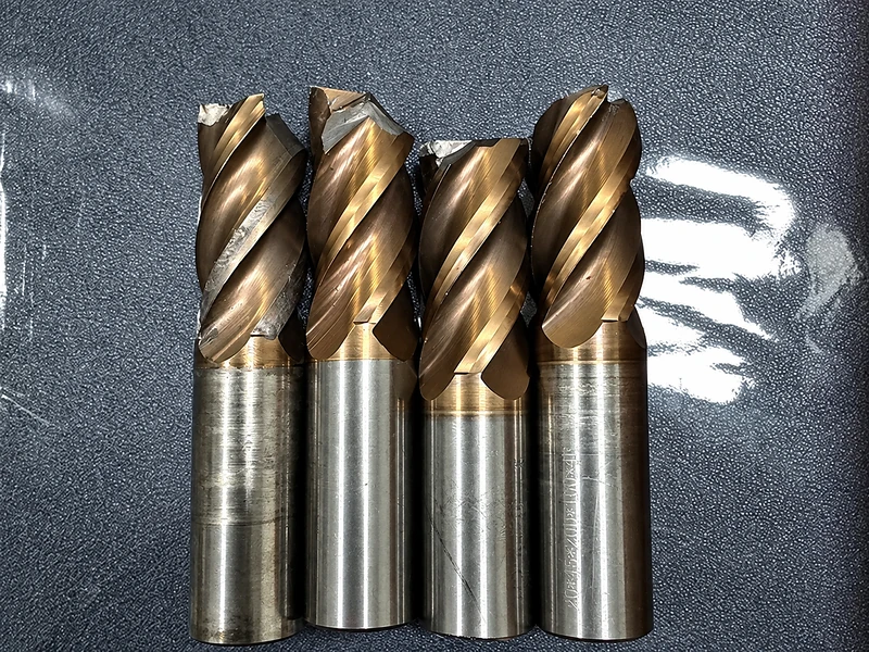 Four end mills with different visible flute geometries